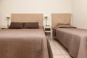 莫桑莱阿尔皮莱Hôtel Les Magnanarelles的两张睡床彼此相邻,位于一个房间里