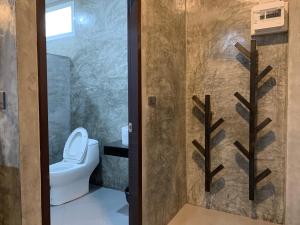 猜也蓬Ban Bunsawaeng Resort的浴室设有卫生间和带玻璃门的淋浴。