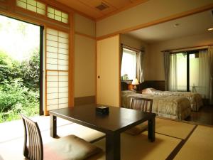 高山游传统日式旅馆的一间带桌子的房间和一间带两张床的房间
