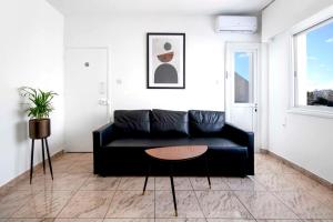 尼科西亚Urban Condo 43 - 1 Bdr的客厅配有黑色沙发和桌子