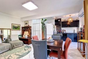 戛纳HENRI CAMILLE REAL ESTATE - ALEXANDRA - 2 bedrooms的厨房以及带桌椅的起居室。