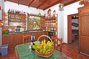 蒂哈拉费Casa Tia Rosalia的厨房配有一张桌子和一篮香蕉