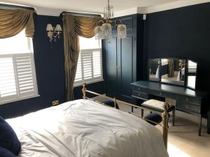 朴次茅斯Luxury 2 bed Georgian Townhouse, Old Portsmouth的一间卧室配有一张床、一张书桌和一面镜子