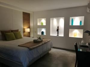 圣萨尔瓦多Hotel Boutique Valverde Santa Elena的卧室配有一张四幅画的墙壁床。