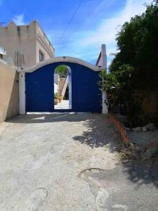 突尼斯Maison à El Omrane .的建筑中带拱门的蓝色车库