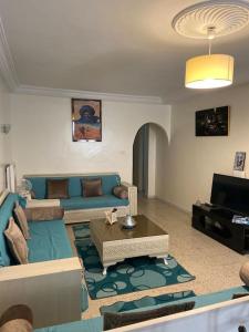 突尼斯Maison à El Omrane .的客厅配有蓝色的沙发和电视