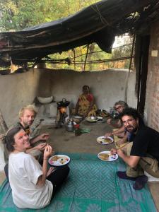 克久拉霍Maji Homestay Khajuraho的一群坐在地板上的人,有盘子的食物