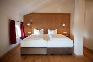 基姆湖畔普林Hotel Luitpold am See的一间卧室配有一张带白色床单的大床