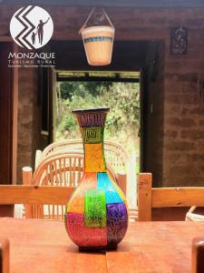 El BarrialMonzaque- paraíso de bachué的一张桌子上一个五颜六色的花瓶