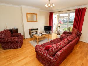 梅布尔索普Acre View的客厅配有红色的沙发和桌子