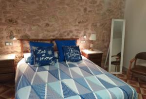 霍斯皮塔勒·德尔英福CAL COT的一间卧室配有一张带蓝色和白色枕头的床