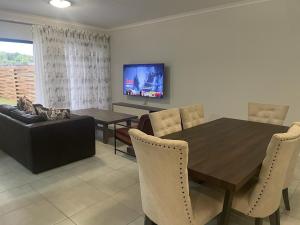 比勒陀利亚Blyde Beach Front Apartment Ground floor的一间带木桌和椅子的用餐室