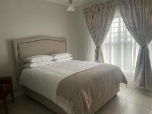 比勒陀利亚Blyde Beach Front Apartment Ground floor的一间卧室设有一张床和一个大窗户