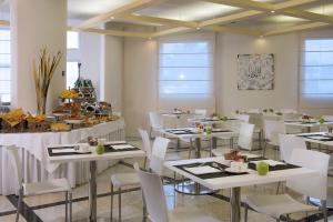 博洛尼亚CDH我的博洛尼亚酒店的用餐室配有白色的桌子和白色的椅子