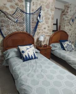 霍斯皮塔勒·德尔英福CAL COT的一间卧室配有两张带蓝白色枕头的床