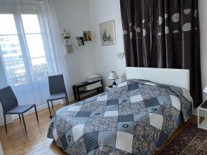 斯特拉斯堡Appartements chez Tante Germaine - Proximité Institutions Européennes的一间卧室配有一张床、两把椅子和一个窗户