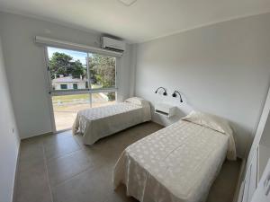 圣克莱门特雷图尤Complejo Bosque y Mar的一间卧室设有两张床和大窗户