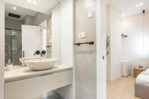 马拉加NEW Sophisticated apartment with balcony & city views by REMS的白色的浴室设有水槽和淋浴。