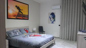 卡塔尼亚THE HOME OF MUSIC STARS的卧室配有一张床,墙上挂着一幅画