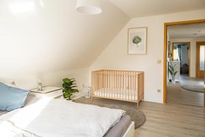 北滩岛Ferienhaus Tidenkieker的一间带婴儿床的卧室和一间带婴儿床的房间