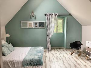 Ploerenles demeures de Kerbosser的一间卧室设有绿色的墙壁、一张床和一把椅子