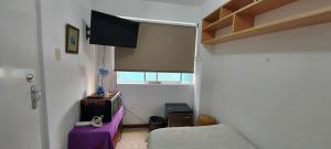 利马Private Cozy room with batroom in Miraflores的客厅配有电视和紫色桌子
