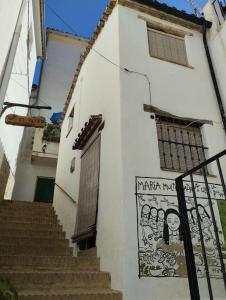 赫纳尔瓜西尔Casa Harillo-Charming 1 bedroom in Genal mountains的白色的建筑,有楼梯和标志