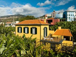 丰沙尔Casa D`Avó Celina的城市中一座黄色的红色屋顶房屋