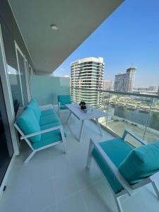 迪拜New Luxury Modern Canal View.的大楼内的阳台配有蓝色椅子和桌子