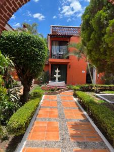 阿吉吉克Hotel Villas Ajijic, Ajijic Chapala Jalisco的一座红色建筑前带喷泉的花园