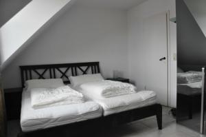 卡尔斯哈根Fewo Peeneblick_LINA的一间卧室配有带白色枕头的床