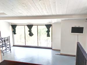 尼姆Spa Nimeslodge的客厅设有大窗户和平面电视。