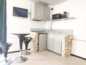 尼姆Spa Nimeslodge的厨房配有白色橱柜、桌子和凳子