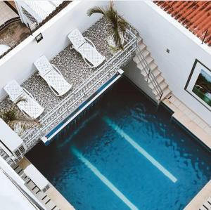梅尔加Hotel Suite Royal的享有带2把草坪椅的游泳池的顶部景致