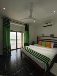 PamunugamaReef Bungalow Hotel的一间卧室配有一张带绿色窗帘的大床