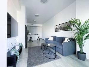 特拉维夫Midtown Tel Aviv Luxury Apartment的客厅配有蓝色的沙发和桌子