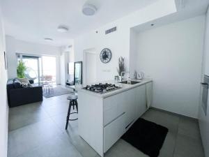 特拉维夫Midtown Tel Aviv Luxury Apartment的客房内的白色厨房配有炉灶
