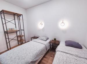 考纳斯K-Town - Apartments ViaBaltic Kaunas的白色墙壁客房的两张床