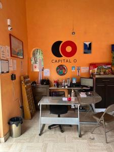 阿吉吉克Hotel Villas Ajijic, Ajijic Chapala Jalisco的一间办公室,里面设有橙色的墙壁和一张桌子,还有一台电脑