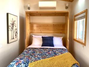 圣路易斯-奥比斯保Sunshine Tiny Home Near Downtown SLO的一间小卧室,配有一张带木制床头板的床