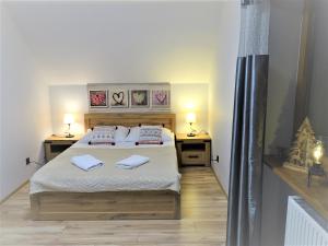 卡尔帕奇Góralska Osada Karpacz -Wood House 8 osobowy Dom Lux的一间卧室配有一张带两张桌子和两条毛巾的床。