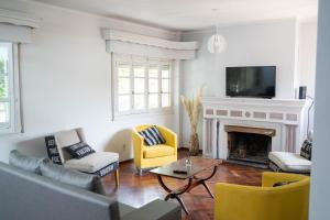 门多萨Amplio y elegante chalet en la mejor zona de Mendoza的客厅设有壁炉和黄色椅子