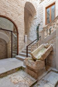 奥斯图尼Il Quinto Elemento - Residence Of Charme的石头建筑,设有楼梯和石水槽