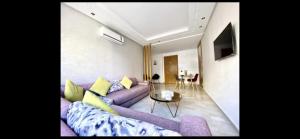 卡萨布兰卡Bel appart+2 ROOM+WIFI+GARE CASA VOYAGEUR+TRAM的客厅配有紫色沙发和桌子