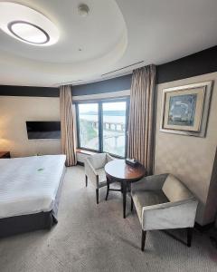 首尔Niagara Hotel的酒店客房,配有一张床、一张桌子和椅子