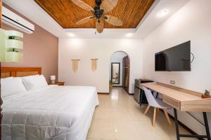塔马林多Hotel Arco Iris的一间卧室配有一张床、一张桌子和吊扇