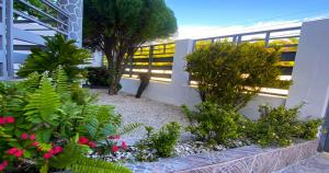 圣斐利-银港Cozy 2BR Near Playa Dorada, 3 Min In Car的一座花园,在一座建筑中种有鲜花和植物