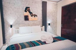 邦劳阿罗那北国度假酒店 的卧室配有白色的床和2条毛巾