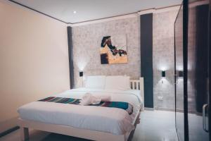 邦劳阿罗那北国度假酒店 的卧室配有一张床,墙上挂有绘画作品