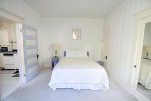 西沃德Brown & Hawkins Historical Apartments的白色卧室配有白色的床和书桌